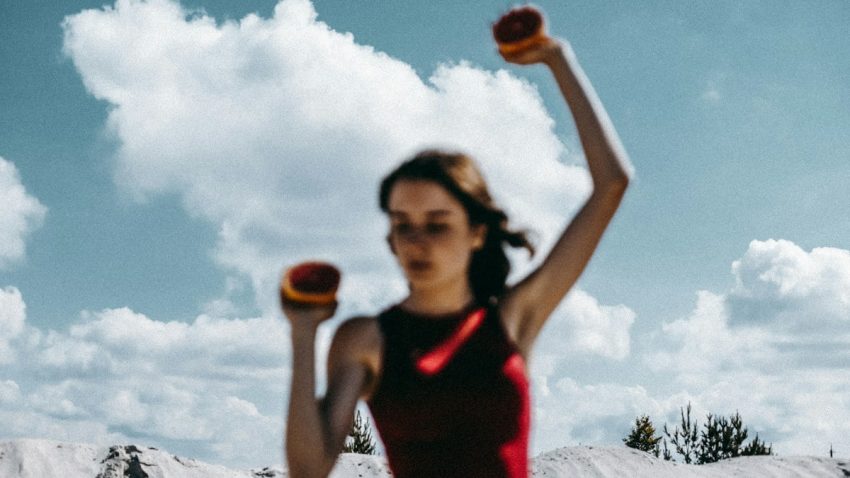 a woman holding two oranges in her hands